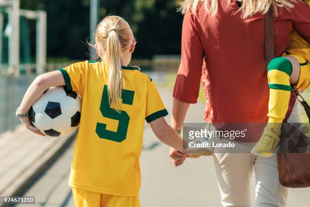 fußball-mama ihre beiden töchter zum fußballtraining begleitet - soccer mum stock-fotos und bilder