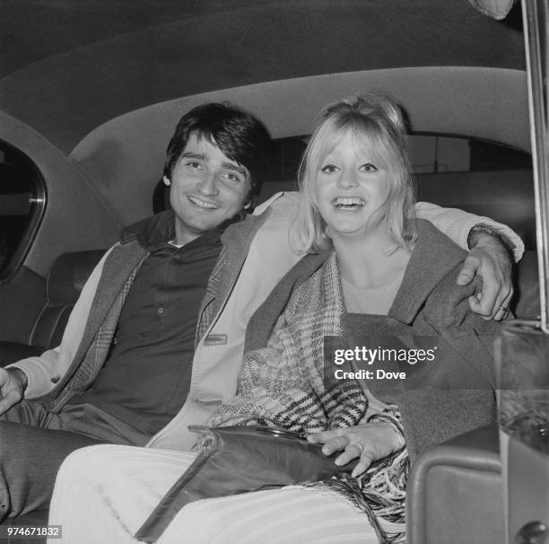 American actress and producer Goldie Hawn with his husband, American actor, dancer, and director Gus Trikonis, sitting in the backseat of a car at...