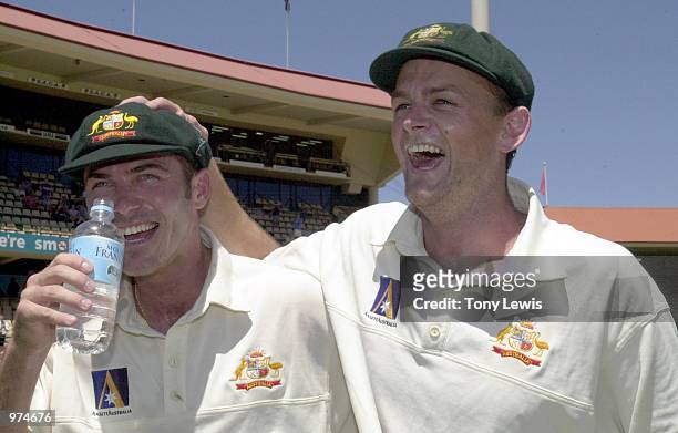 Damien Martyn and Adam Gilchrist celebrate victory by five wickets over the West Indies during the fifth days play of the Third Test match between...