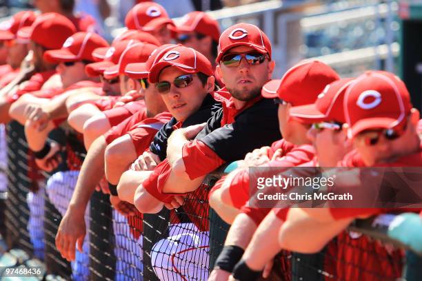 Cincinnati Reds players wait in the dugout for play to begin against the Cleveland Indians during a spring training game at Goodyear Ballpark on...