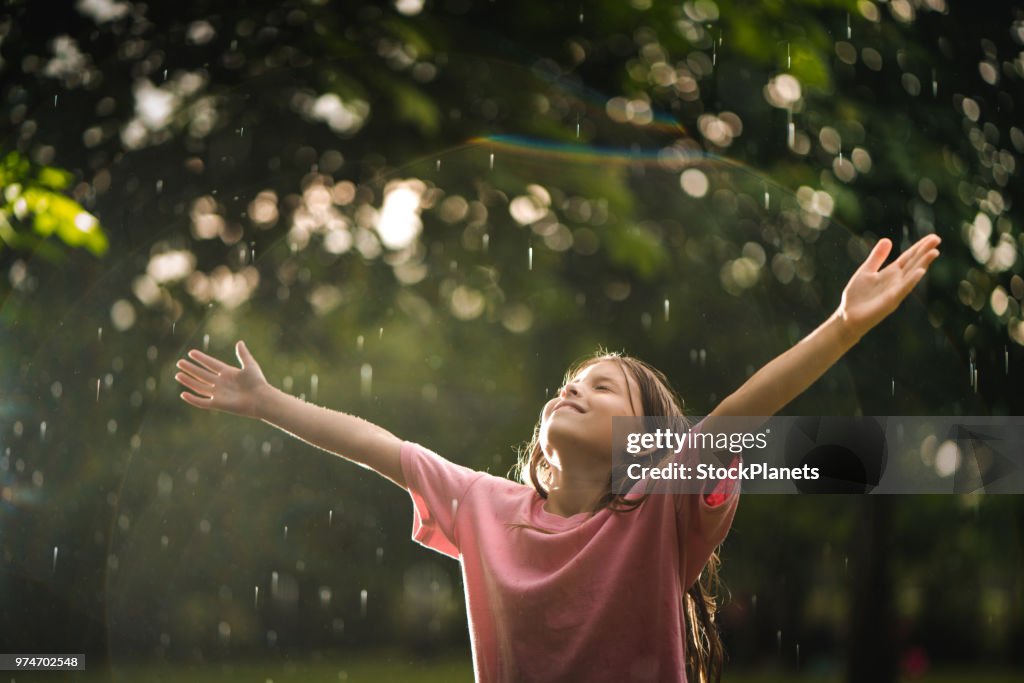 Chica de belleza está feliz porque la lluvia
