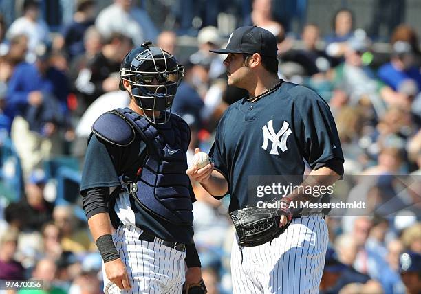 Pitcher Joba Chamberlain of the New York Yankees talks with catcher Francisco Cervelli after taking the mound in relief against the Tampa Bay Rays...