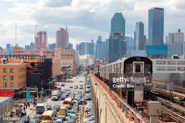 u-bahnzug nähern erhöhten u-bahn-station in queens, new york  - metro transporte stock-fotos und bilder