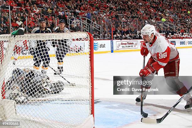 Tomas Holmstrom of the Detroit Red Wings fires in the rebound on Dan Ellis of the Nashville Predators during an NHL game at Joe Louis Arena on March...