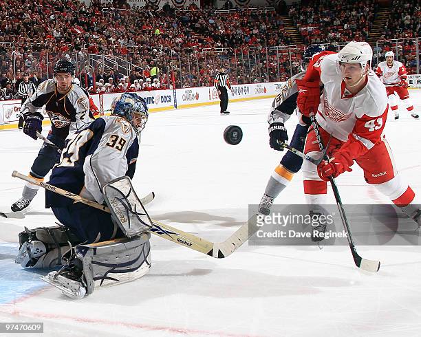 Dan Ellis of the Nashville Predators makes a save on a shot by Darren Helm of the Detroit Red Wings during an NHL game at Joe Louis Arena on March 5,...