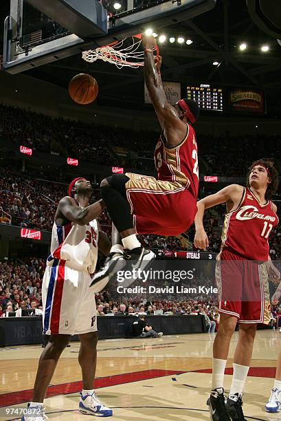 LeBron James of the Cleveland Cavaliers finishes off a dunk over Kwame Brown of the Detroit Pistons on March 5, 2010 at The Quicken Loans Arena in...