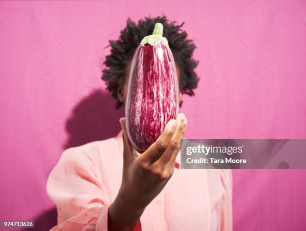 woman holding aubergine in front of face - comida vegetariana fotografías e imágenes de stock