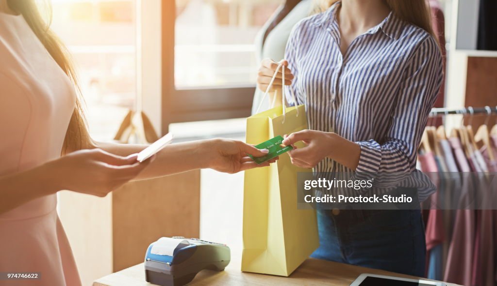 Mulher compra roupas com cartão de crédito