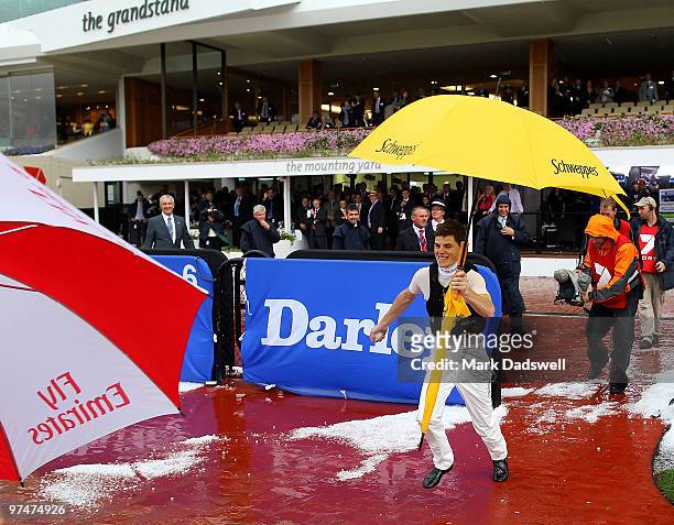 Jockey Craig Williams chases Claire Lindrop with a handfull of hail after a storm hit Flemington Racecourse on Super Saturday on March 6, 2010 in...