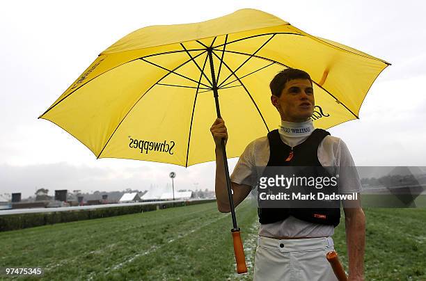 Jockey Craig Williams inspects the track after a storm hit Flemington Racecourse on Super Saturday on March 6, 2010 in Melbourne, Australia.