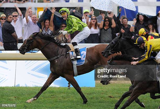 Michael Walker celebrates with a Pukana aboard Military Move as he crosses the line to win race 8 The Telecom New Zealand Derby during the Telecom...