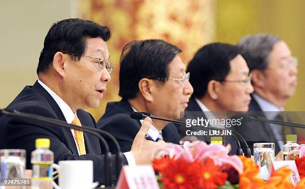 Chinese Commerce Minister Chen Deming answers a question as Zhang Ping , director of the National Development and Reform Commission, Finance Minister...