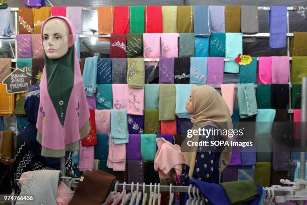 Woman is browsing hijabs collection in a store in Sungai Petani during Eid al-Fitr night eve. On June 15 Muslim throughout the world will celebrate...