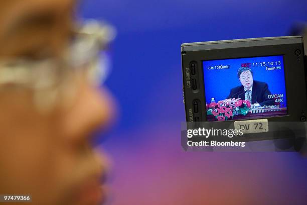 Zhou Xiaochuan, governor of the People's Bank of China, is seen on the monitor of a camera man during a news conference at the Great Hall of the...
