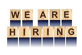Word We Are Hiring, composed of letters on wooden construction cubes. White background, isolated Concept business, finance.