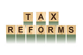 Word Tax Reforms, composed of letters on wooden construction cubes. White background, isolated Concept business, finance.