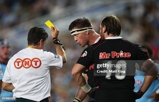 Referee Paul Marks gives a yellow card to Andy Goode of the Sharks as Sharks captain John Smit argues during the round four Super 14 match between...