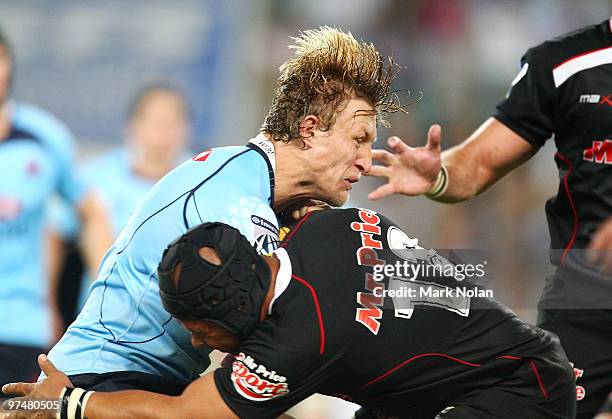 Lachie Turner of the Waratahs is tackled during the round four Super 14 match between the Waratahs and the Sharks at the Sydney Football Stadium on...