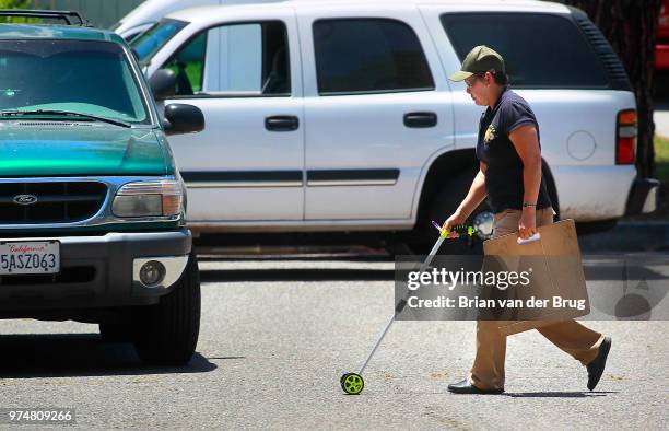 Los Angeles Sheriff's investigators takes measurements on the street outside a home at 8620 Santa Susana Place June 8 2012 in Canoga Park. Sheriff's...