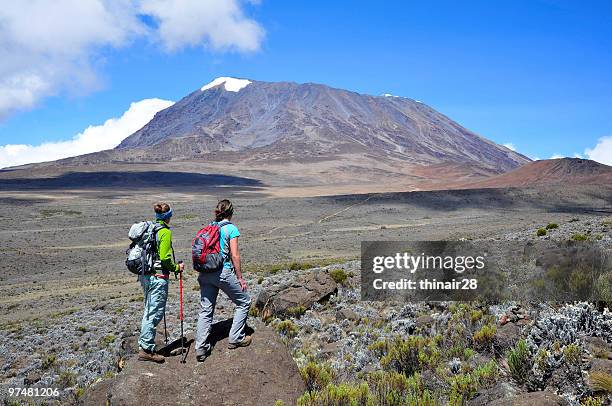 two ladies hiking mt kilimanjaro on a sunny clear day - kilimanjaro bildbanksfoton och bilder