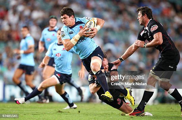 Tom Carter of the Waratahs runs the ball during the round four Super 14 match between the Waratahs and the Sharks at the Sydney Football Stadium on...