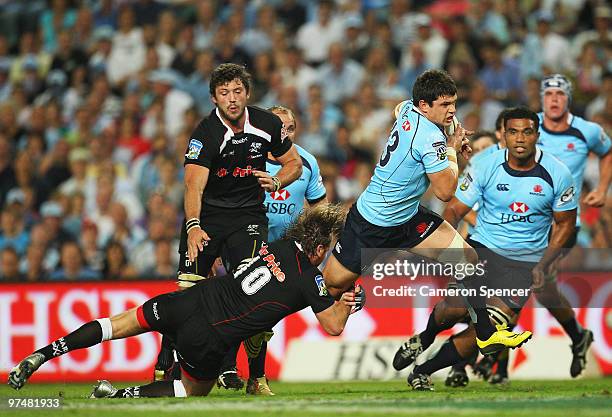 Tom Carter of the Waratahs makes a break during the round four Super 14 match between the Waratahs and the Sharks at the Sydney Football Stadium on...