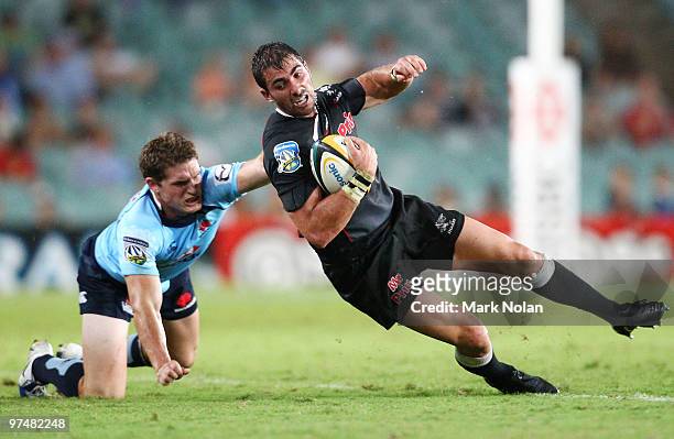 Ruan Piennaar of the Sharks is tackled by Josh Holmes of the Waratahs during the round four Super 14 match between the Waratahs and the Sharks at the...