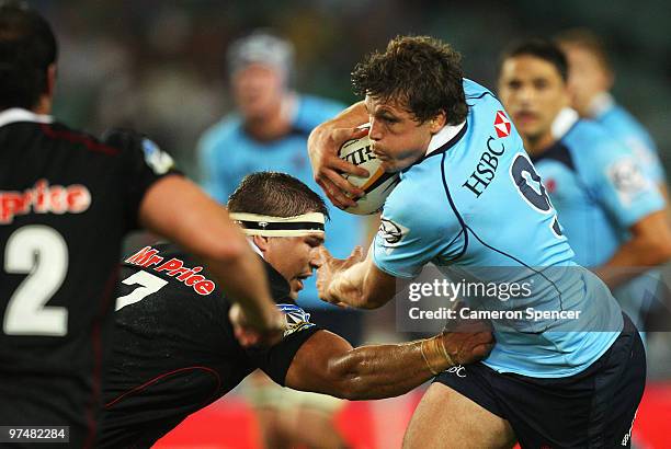 Luke Burgess of the Waratahs is tackled during the round four Super 14 match between the Waratahs and the Sharks at the Sydney Football Stadium on...