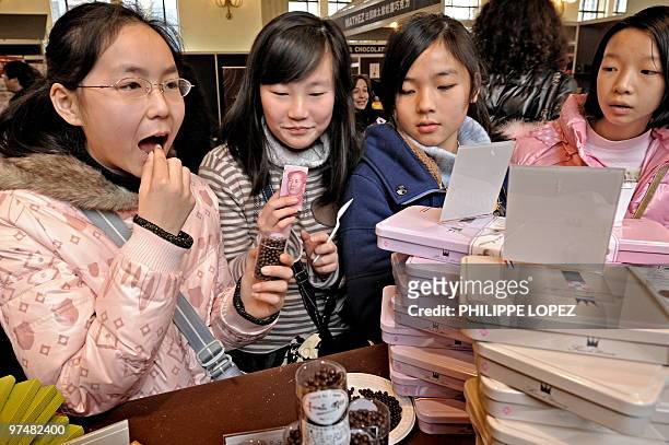 Chine-France-alimentation-consommation Chinese children taste chocolate before buying at a stall of the Salon du Chocolat in Shanghai on January 21,...