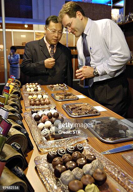 Chinese man chats with a French exhibitor at the Salon Du Chocolat, China's first chocolate fashion show, in Beijing 10 June 2005. China's first...