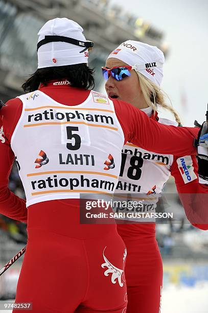 Third-placed Therese Johaug hugs winner Marit Björgen, both of Norway, after the ladies' cross country pursuit at the FIS World Cup Lahti Ski Games,...