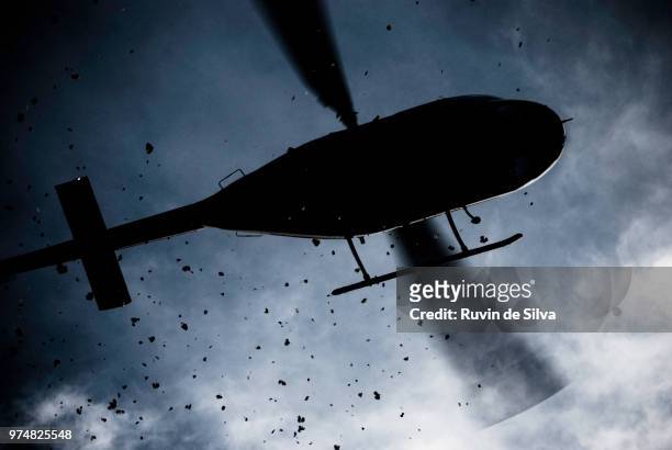 helicopter scattering dirt seen from below - helicopter stock pictures, royalty-free photos & images
