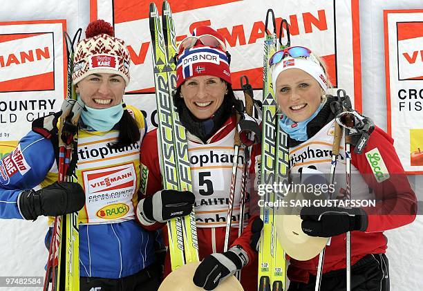 Second-placed Justyna Kowalczyk of Poland, winner Marit Björgen and third-placed Therese Johaug, both of Norway, celebrate on the podium after the...