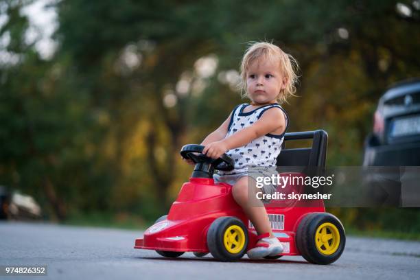 cute little boy driving his toy car outdoors. - toy car stock pictures, royalty-free photos & images