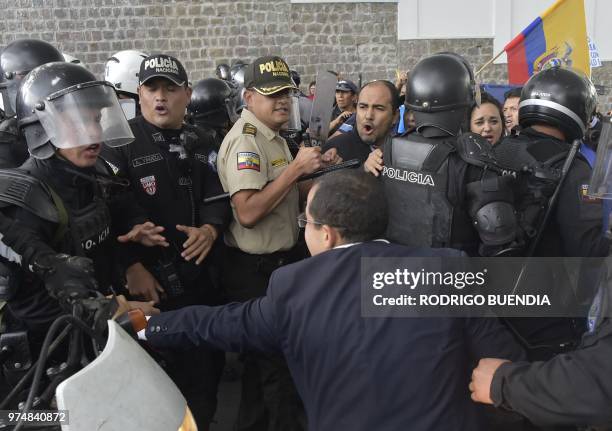 Lawmakers aligned with former Ecuadoran president Rafael Correa struggle with police officers upon arriving at the National Assembly in Quito as...