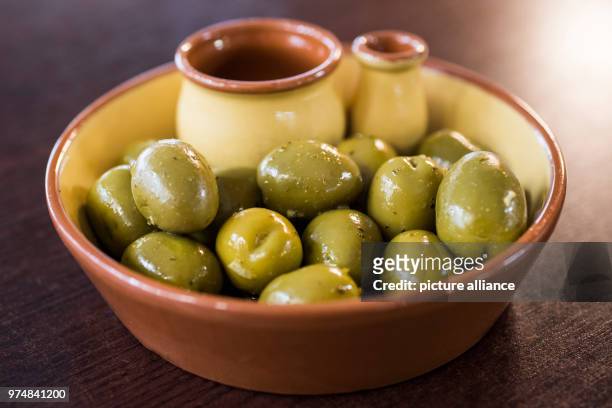 June 2018, Berlin, Germany: Green olives from Spain are placed in a bowl. Planned punitive tariffs by the US regarding Spanish olives have received...