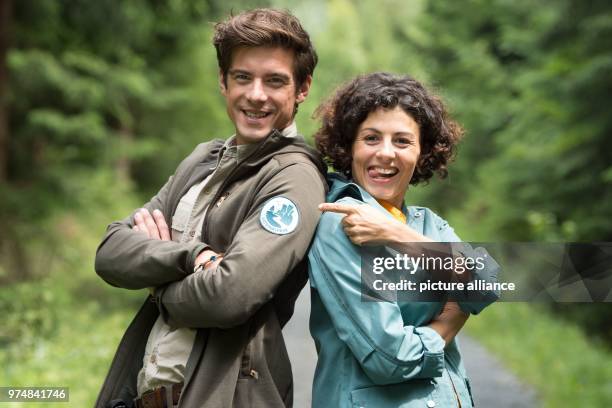 June 2018, Germany, Krippen: The German actors Liza Tzschirner and Philipp Danne standing next to each other in a woodland in the Saxon Switzerland...