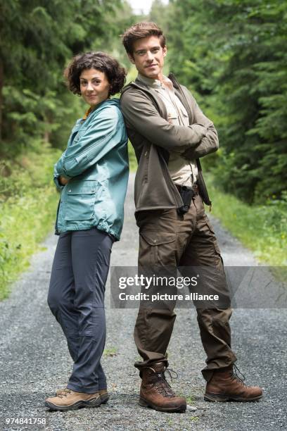 June 2018, Germany, Krippen: The German actors Liza Tzschirner and Philipp Danne standing next to each other in a woodland in the Saxon Switzerland...