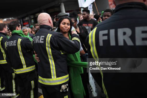 People stop to hug firefighters during a silent march to St Marks Park where an open Iftar will take place on the one year anniversary of the...