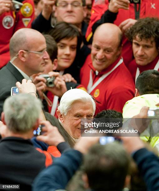 Pope Benedict XVI smiles to Italian Civil Protection volunteers and photographers as he arrives for the Audience to Italian organization in Aula...