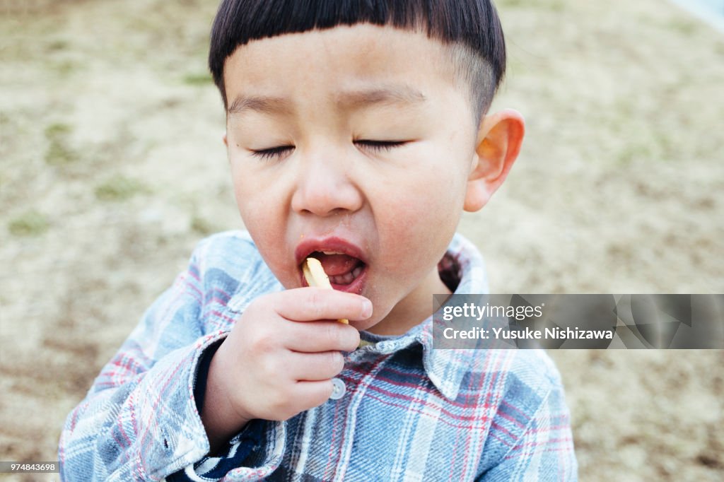 A Boy eating french fries