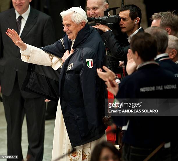 Pope Benedict XVI waves to Italian Civil Protection volunteers as he wears a jacket of the Italian organization during the Audience in Aula Paolo VI...