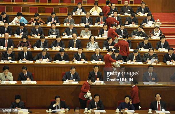 Hostesses serve tea to delegates during the opening session of the annual National People's Congress at the Great Hall of the People in Beijing on...