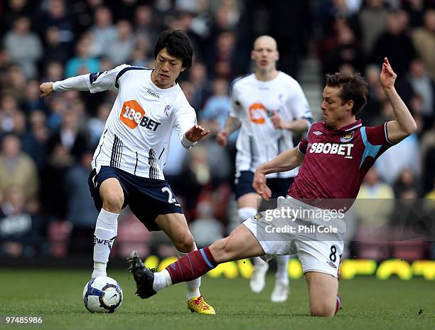 Scott Parker of West Ham United tackles Lee Chung-Yong of Bolton Wanderers during the Barclays Premier League match between West Ham United and...