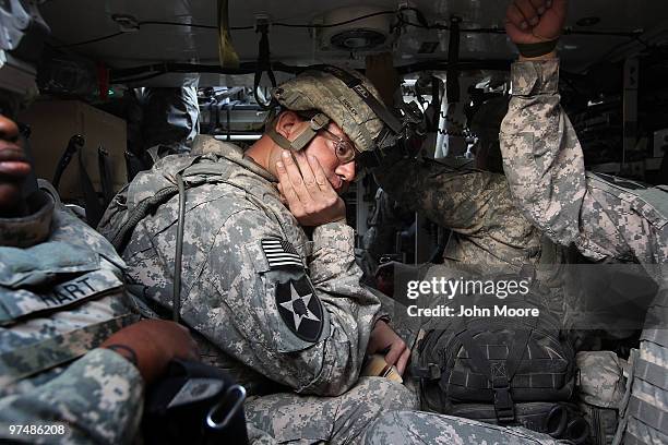 Army chaplain Carl Subler rides inside a Stryker armored personel carrier while moving between bases to celebrate Catholic Mass for soldiers on March...