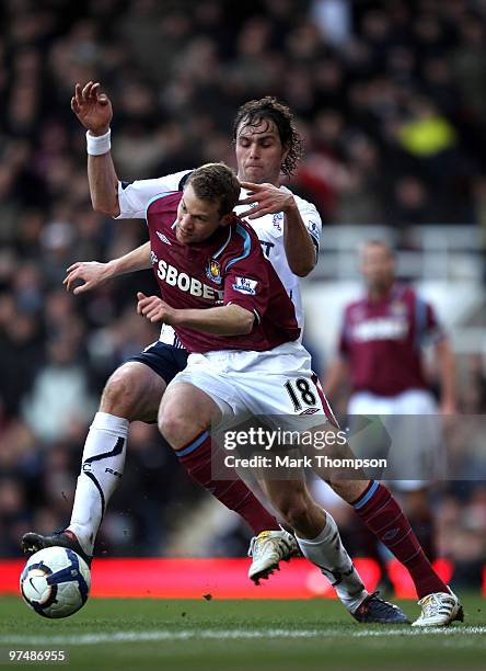 Jonathan Spector of West Ham United tangles with of Johan Elmander of Bolton Wanderers during the Barclays Premier League match between West Ham...