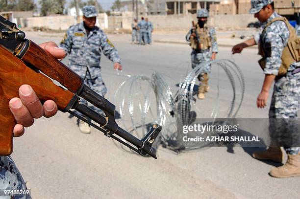 Iraqi police commandos install barbed wire around a polling station in the city of Ramadi, west of Baghdad, on March 6, 2010. Al-Qaeda in Iraq has...