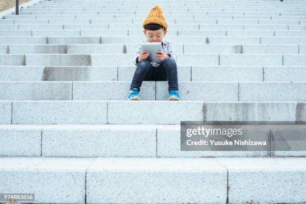 a boy who operates a tablet - ワイヤレスアプリケーションプロトコル ストックフォトと画像