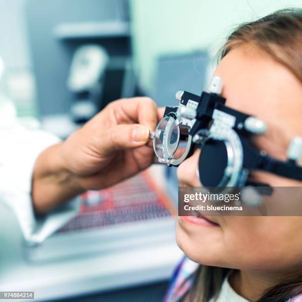 girl undergoing eye test in clinic - astigmatism stock pictures, royalty-free photos & images