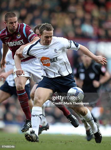 Matthew Upson of West Ham United tangles with Kevin Davies of Bolton Wanderers during the Barclays Premier League match between West Ham United and...